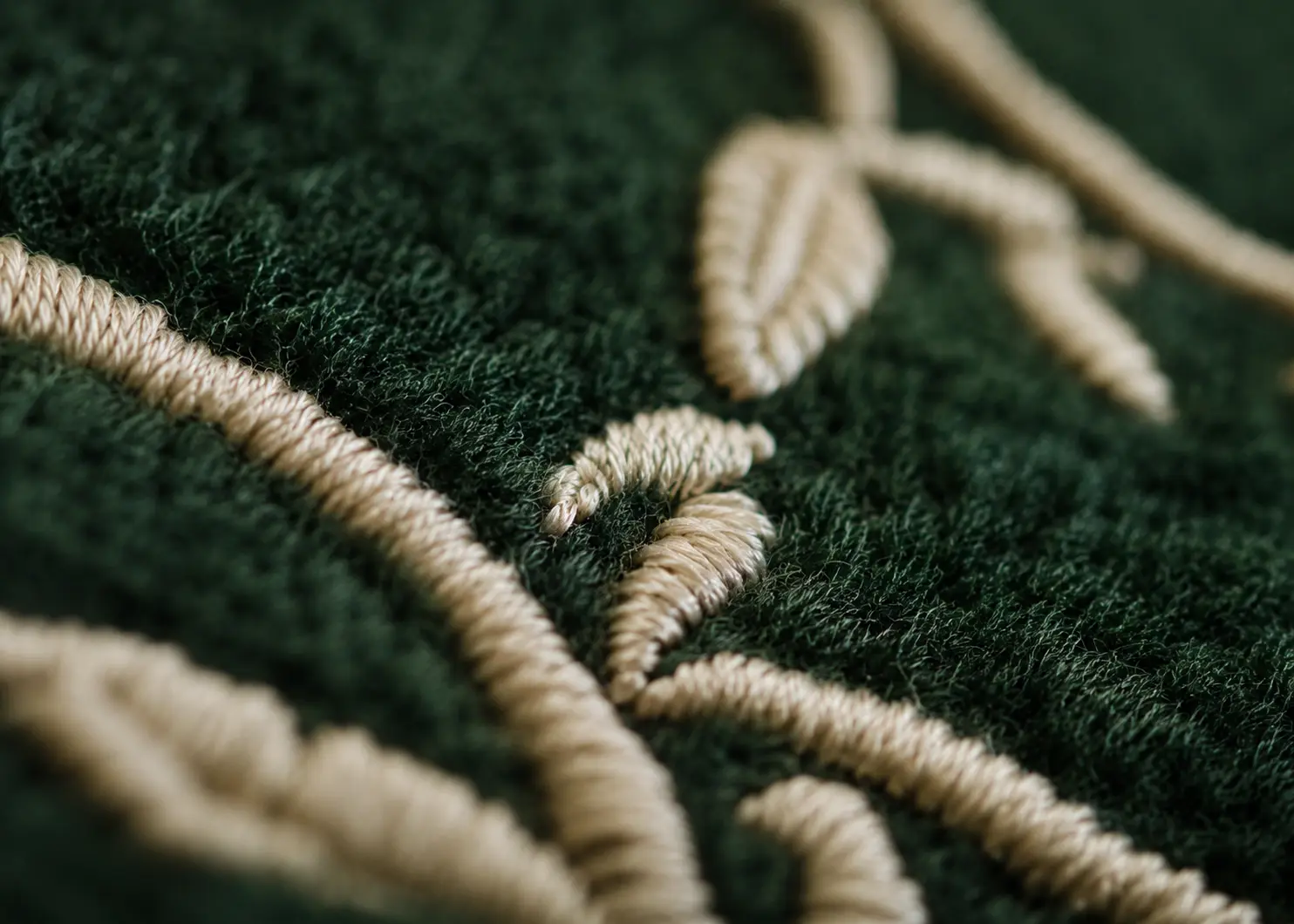 Cream embroidery stitching on forest green fleece